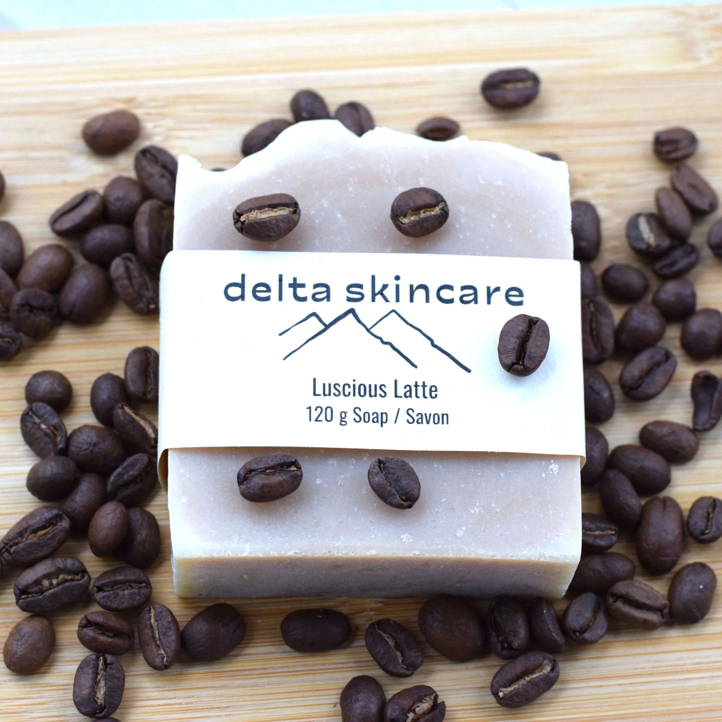 Delta Skincare Luscious Latte soap bar on a wooden surface with coffee beans