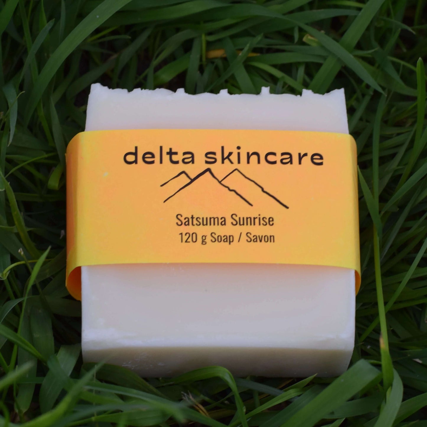 Delta Skincare soap bar with yellow label on grass