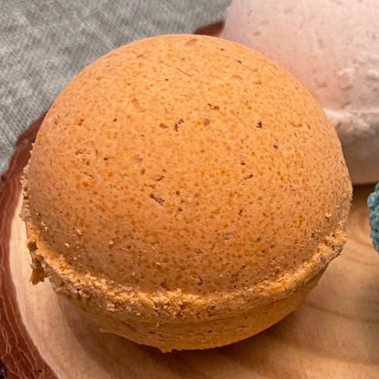 Orange bath bomb on wooden tray with textured surface for spa and relaxation