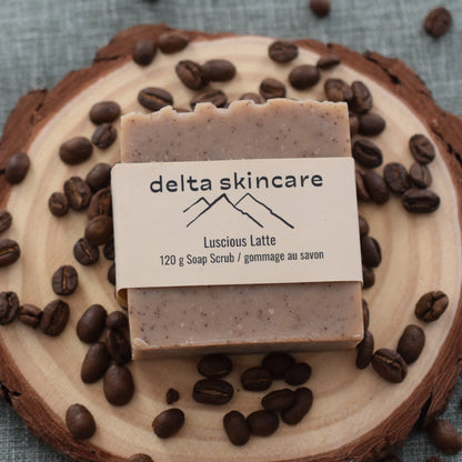 Delta Skincare Luscious Latte soap scrub on wood slice with coffee beans