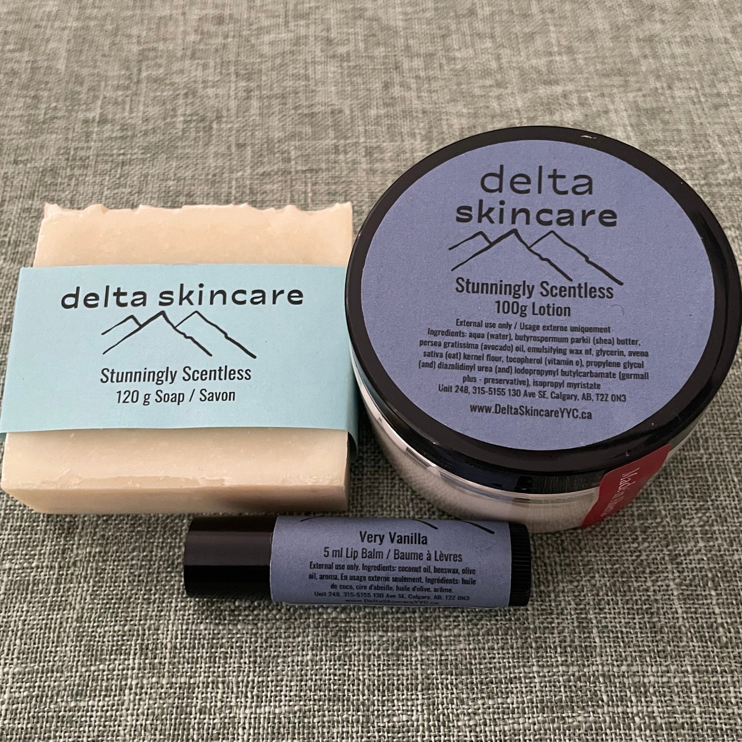 Delta Skincare products including a lotion jar, lipbalm, and bar soap on a textured surface