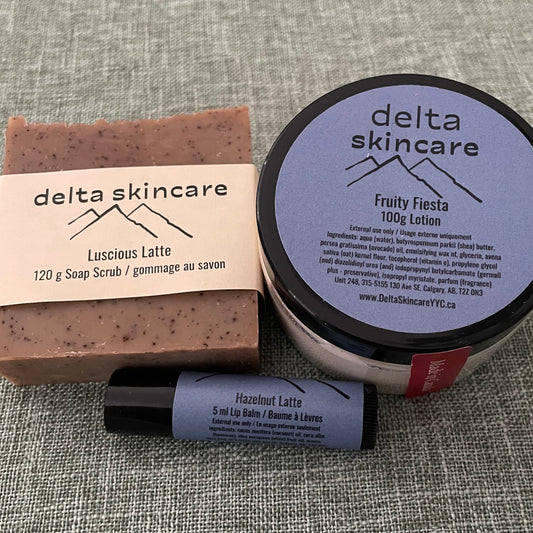 Delta Skincare products including a lotion jar, bar soap, and lip balm on a textured gray surface.
