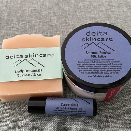 Delta Skincare products including a lotion jar, lip balm, and bar soap on a textured gray surface