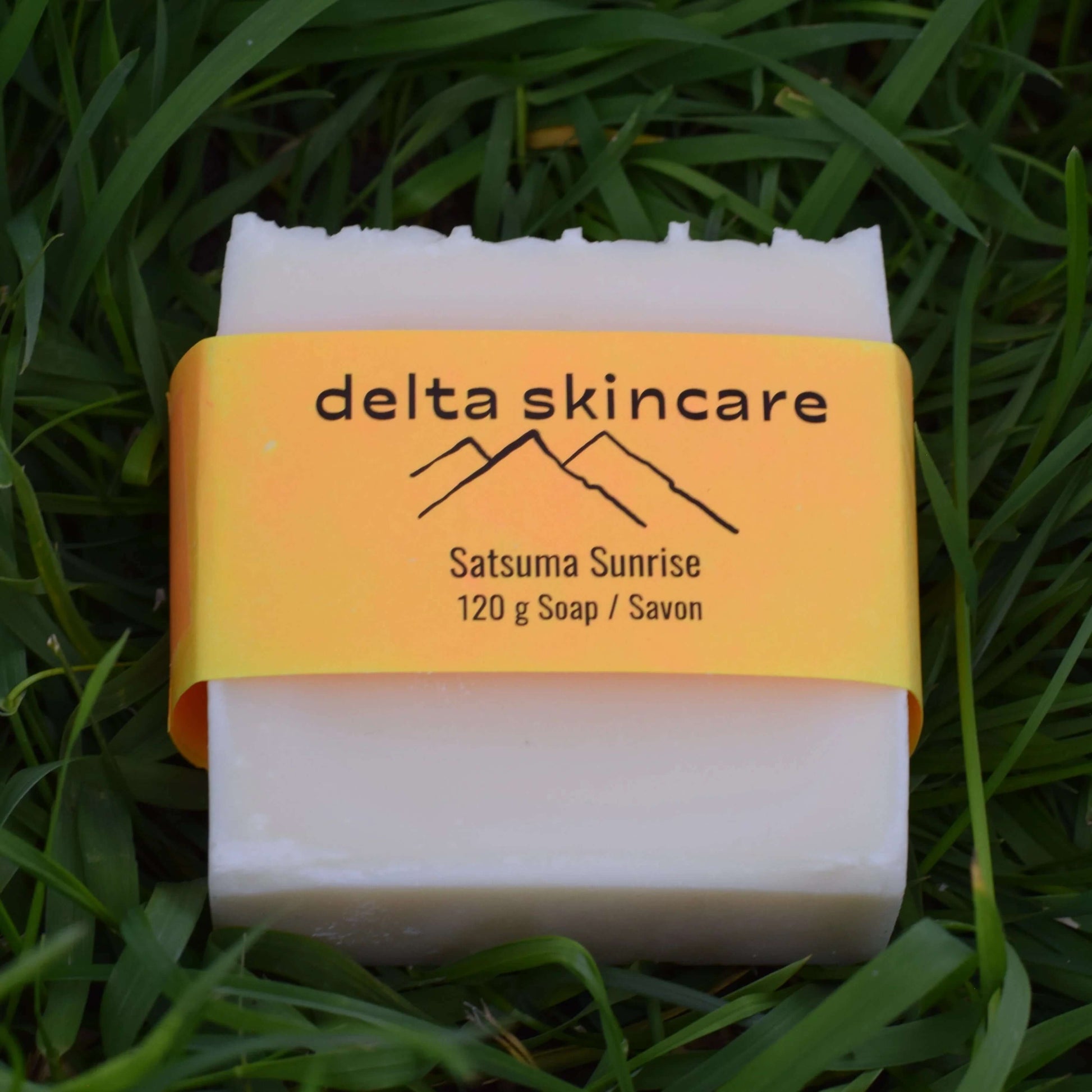Delta Skincare soap bar with yellow label on grass