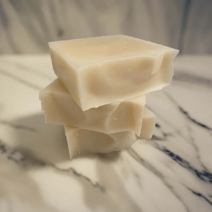 Trio of natural handmade soap bars stacked on marble surface
