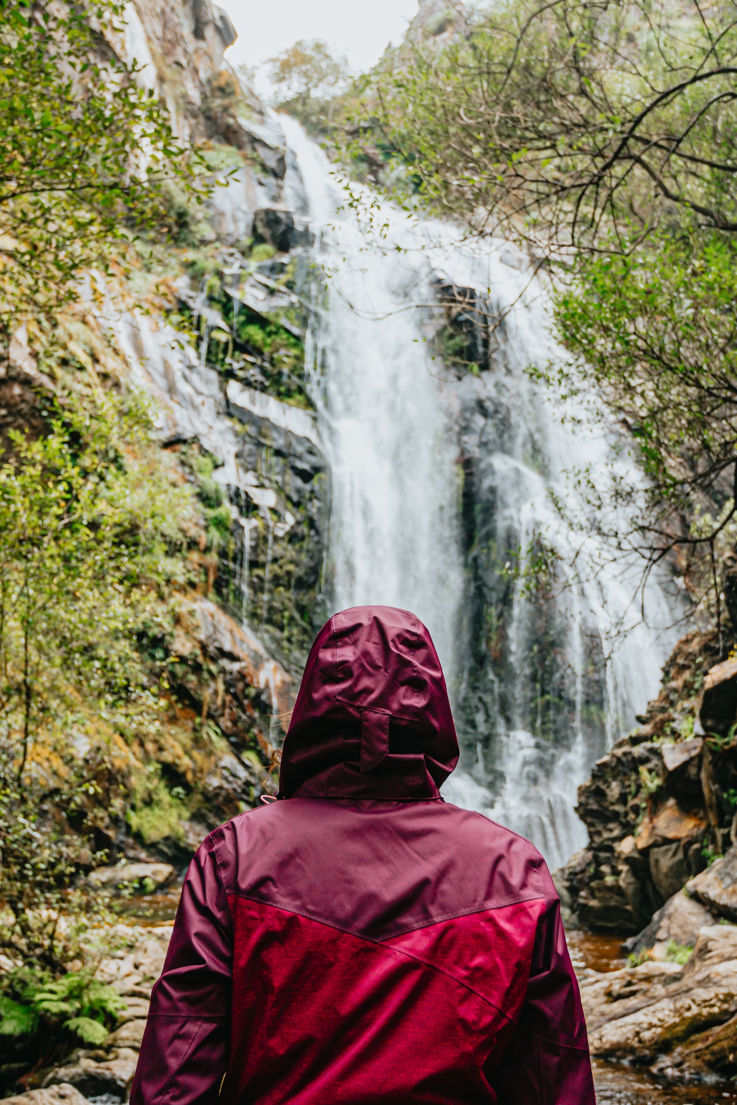 Red raincoat at waterfall